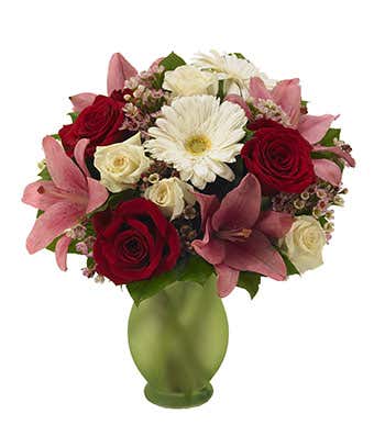 Red roses, pink lilies and gerbera daisies in green vase