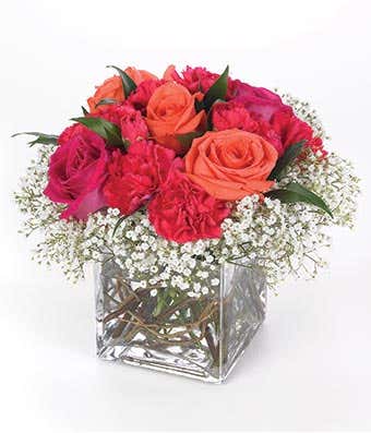 Red roses and orange roses in square glass vase