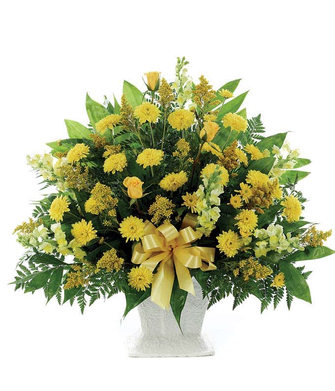 Yellow snapdragons and mums in a funeral flower arrangement