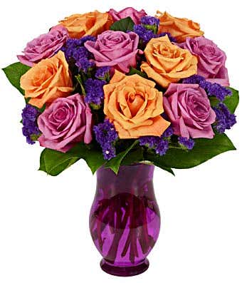 Purple roses arranged with orange roses in a purple vase