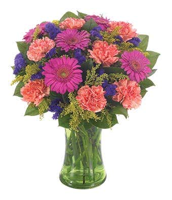 Hot pink gerbera daisies, orange carnations and purple flowers in vase