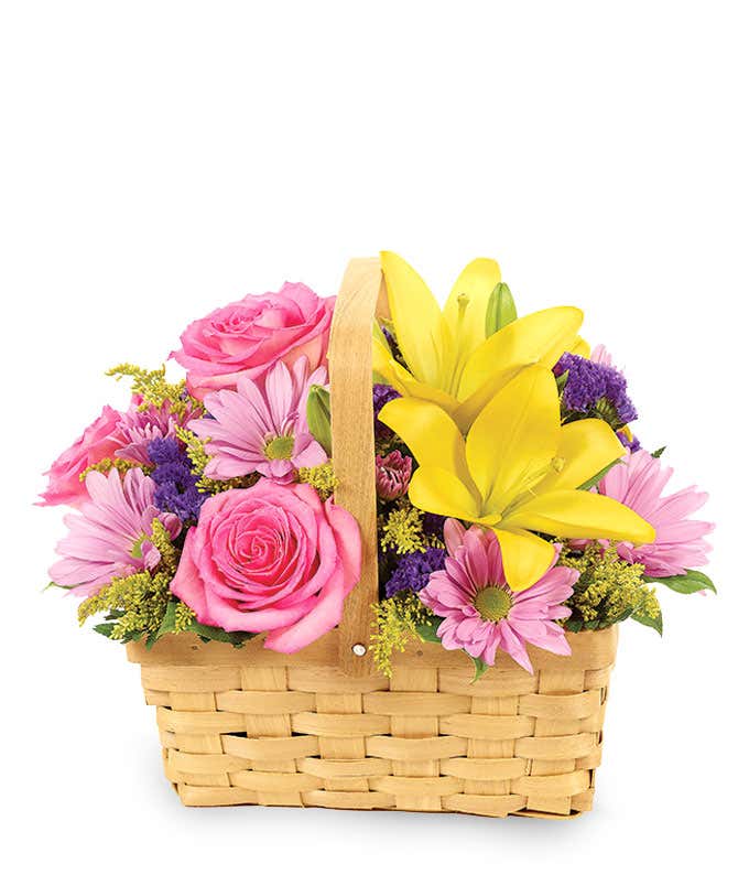 Yellow lilies, pink roses and purple daisies in a handled basket