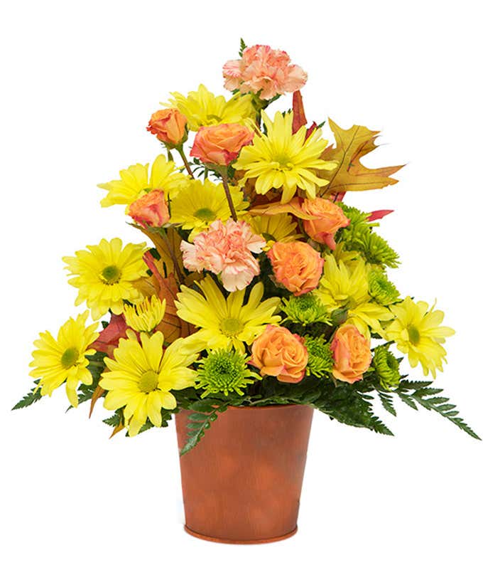 Yellow daisies with orange carnations in an orange pot