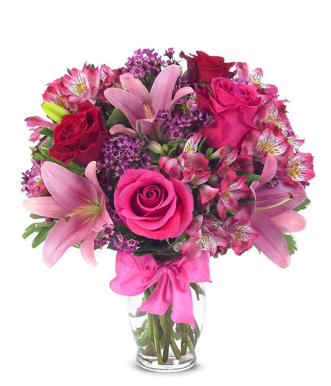 Red roses, pink lilies and pink alstroemeria and glass vase