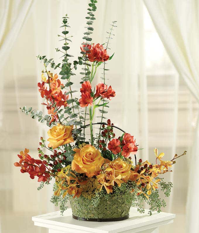 Tribute basket with yellow roses, red alstroemeria and orchids