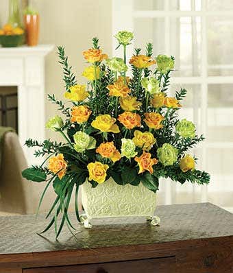 Yellow roses, orange roses and green roses in a unique planter