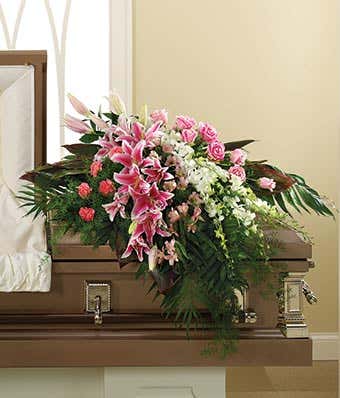 Pink stargazer lilies, white orchids and pink carnations in a casket spray