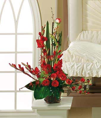 Sympathy arrangement of red gladiolus, roses and orchids