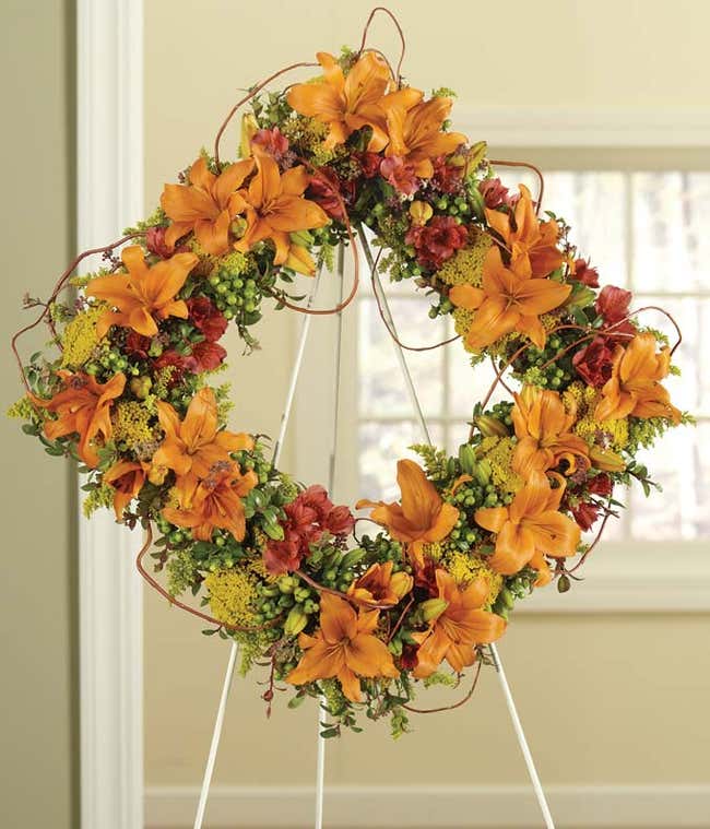 Orange lilies and red alstroemeria sympathy standing wreath