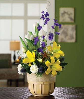Yellow lilies and white tulips in a get well flower basket