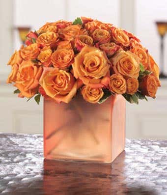 Orange roses and orange spray roses in colorful vase