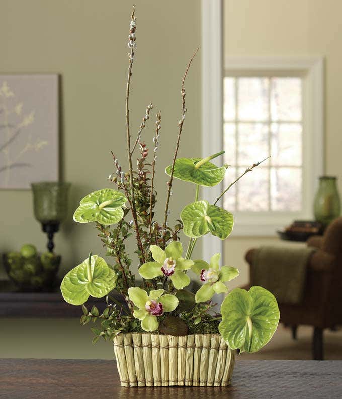 Green orchids and huckleberry in a woven basket