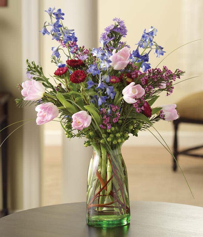 Pink Tulips and blue delphinium in a milk jar