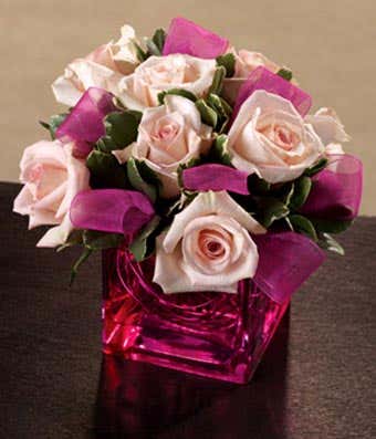 Pink roses with ribbon in pink square vase