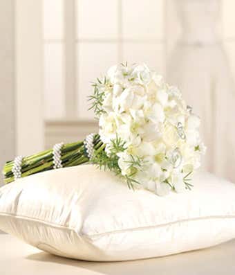 White roses, white tulips and orchids arranged in a bridesmaid bouquet