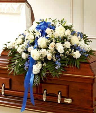 White roses and blue delphinium floral casket cover