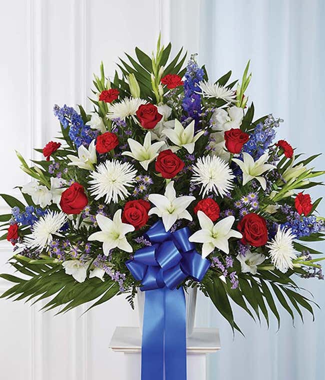 Red roses, white lilies and white mums in a sympathy basket