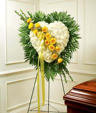 White flowers and yellow flowers in heart shaped standing spray