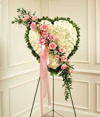 White flowers with pink rose break in heart shaped standing spray