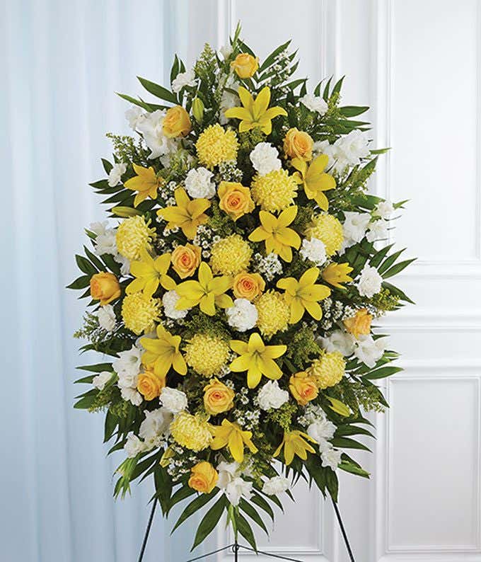 Yellow roses, yellow mums and white flowers in a standing spray