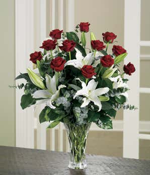 Long stem red roses delivered with white lilies in glass vase