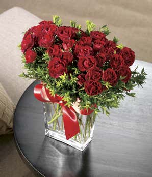 Red spray roses delivered by florist in glass vase